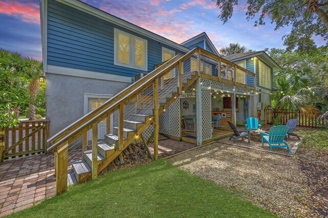 13 32nd Ave, Isle Of Palms, SC 29451 - back of property at dusk with a patio, a fire pit, stairway, and stucco siding