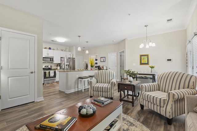 living area with an inviting chandelier, visible vents, and dark wood-type flooring