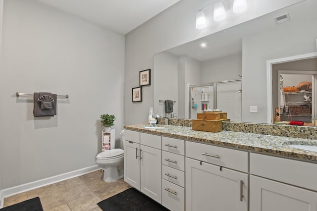 full bathroom featuring double vanity, a shower stall, toilet, and visible vents