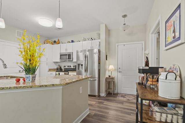 kitchen featuring a sink, appliances with stainless steel finishes, pendant lighting, and dark wood-style flooring