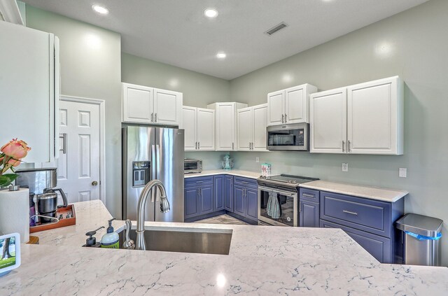 6179 Fieldstone Cir, Charleston, SC 29414 - kitchen with appliances with stainless steel finishes, blue cabinetry, a sink, white cabinets, and recessed lighting