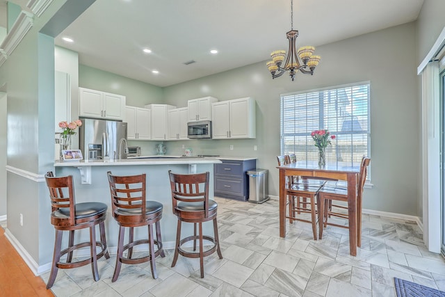 6179 Fieldstone Cir, Charleston, SC 29414 - kitchen with stainless steel appliances, a breakfast bar area, baseboards, a peninsula, and recessed lighting