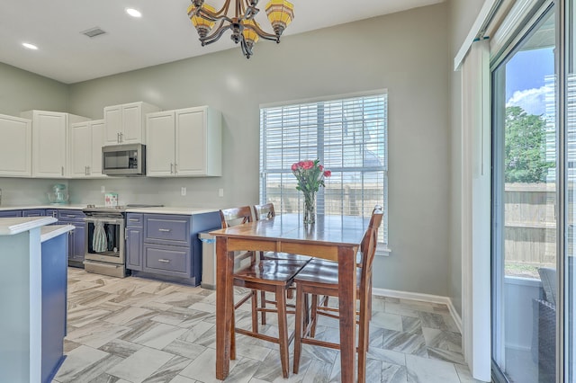 6179 Fieldstone Cir, Charleston, SC 29414 - kitchen with appliances with stainless steel finishes, gray cabinetry, light countertops, a chandelier, and white cabinets