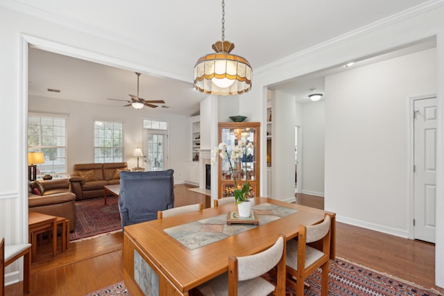 dining area with ceiling fan and wood-type flooring