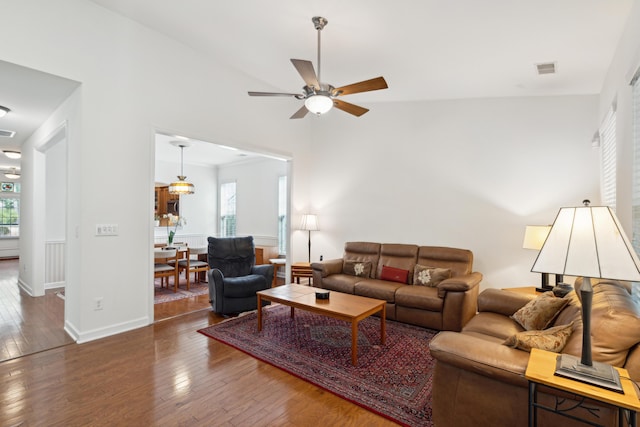 living room featuring ceiling fan and dark hardwood / wood-style flooring