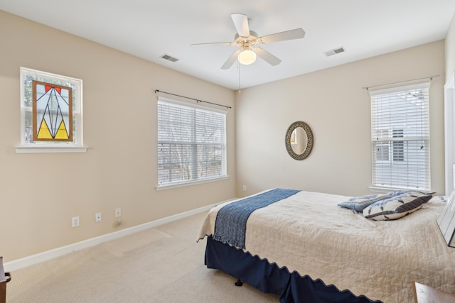 carpeted bedroom featuring ceiling fan and multiple windows