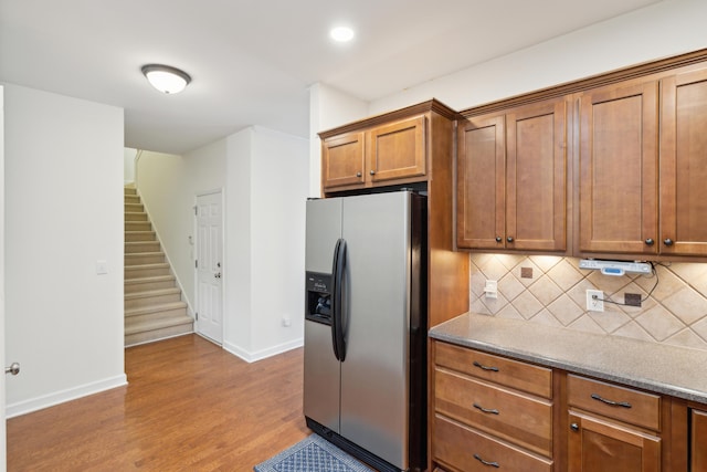 kitchen with decorative backsplash, stainless steel fridge, and light hardwood / wood-style flooring