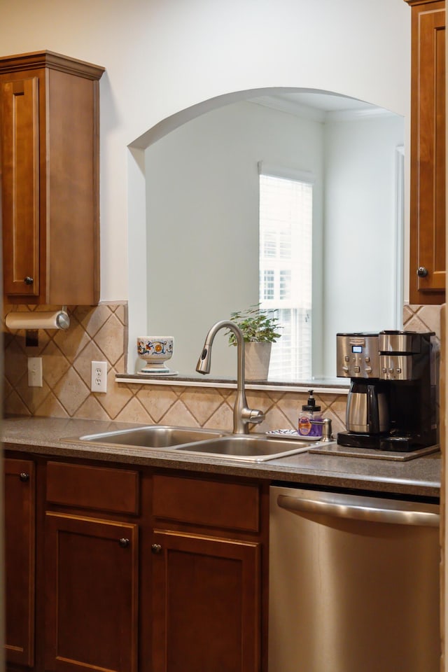 kitchen with decorative backsplash, stainless steel dishwasher, and sink