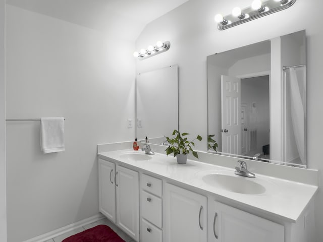 bathroom featuring vanity, tile patterned flooring, and vaulted ceiling