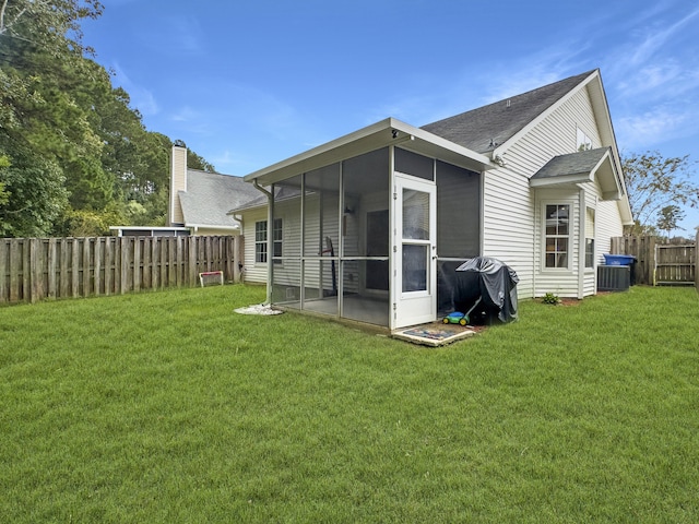 back of property with a sunroom and a yard