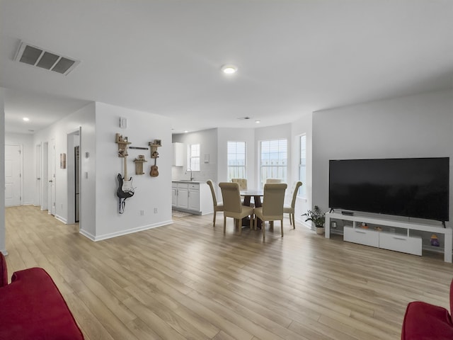 living room with sink and light wood-type flooring