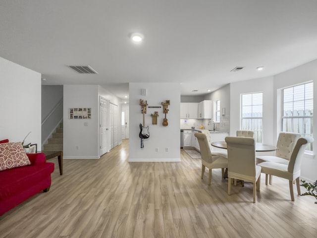 dining space with sink and light hardwood / wood-style flooring