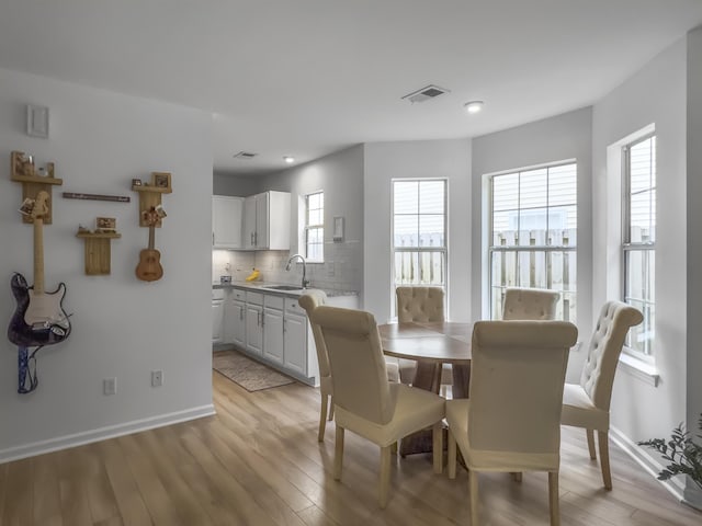 dining room featuring sink and light wood-type flooring