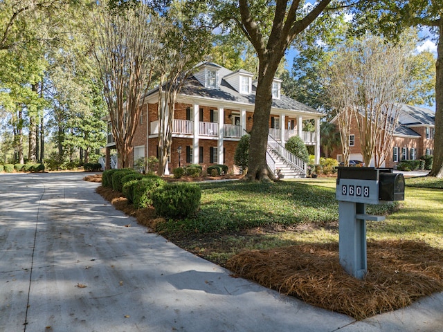 neoclassical home with a front yard and covered porch