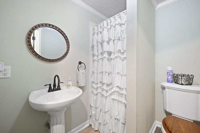 bathroom featuring wood-type flooring, a textured ceiling, toilet, and crown molding