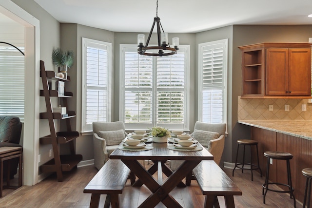 dining area with hardwood / wood-style floors and a chandelier