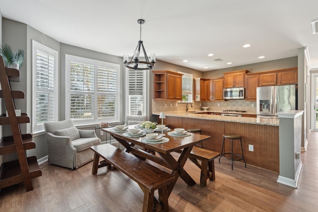 dining area featuring a chandelier, hardwood / wood-style floors, and sink