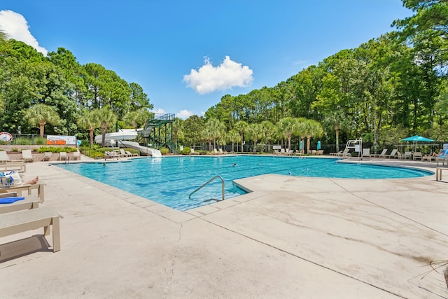 view of pool featuring a water slide and a patio area