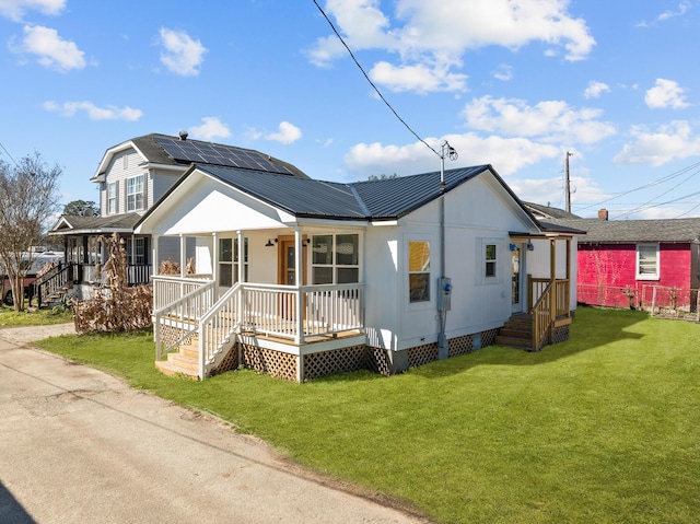 view of front of property featuring crawl space, metal roof, a porch, and a front yard