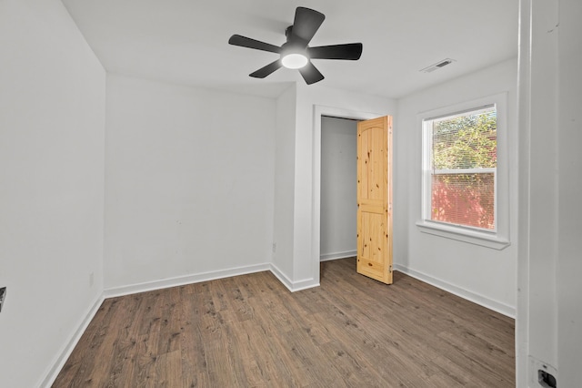 unfurnished bedroom with ceiling fan, wood finished floors, visible vents, and baseboards