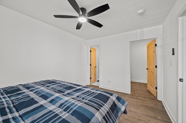 bedroom featuring a ceiling fan, baseboards, and wood finished floors