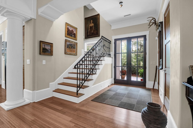 entrance foyer featuring wood-type flooring, french doors, and ornate columns