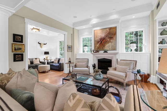 living room featuring ornamental molding, an inviting chandelier, light hardwood / wood-style floors, and a wealth of natural light