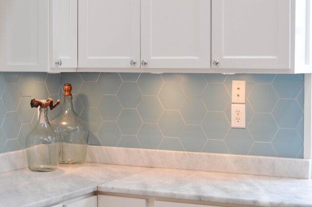 details with light stone countertops, white cabinets, and tasteful backsplash