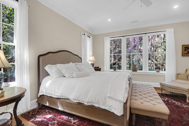 bedroom with wood-type flooring, crown molding, and ceiling fan