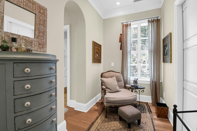 sitting room with light hardwood / wood-style flooring, a wealth of natural light, and crown molding