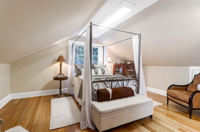 bedroom featuring vaulted ceiling and hardwood / wood-style flooring