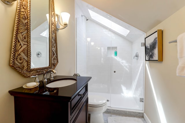 bathroom with vanity, a skylight, toilet, and a shower with door