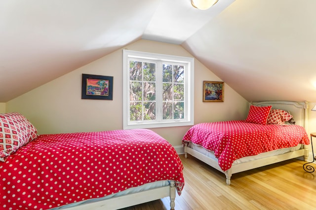 bedroom with wood-type flooring and vaulted ceiling