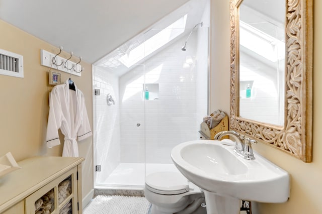 bathroom with a healthy amount of sunlight, lofted ceiling with skylight, toilet, and an enclosed shower