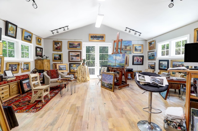 living room featuring vaulted ceiling with beams, light hardwood / wood-style floors, track lighting, and french doors