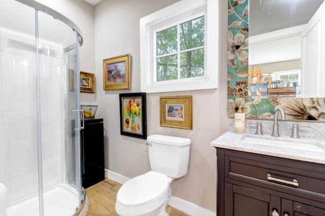 bathroom featuring vanity, hardwood / wood-style flooring, a shower with shower door, and toilet