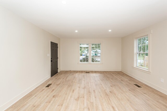 empty room with light wood-type flooring and a healthy amount of sunlight