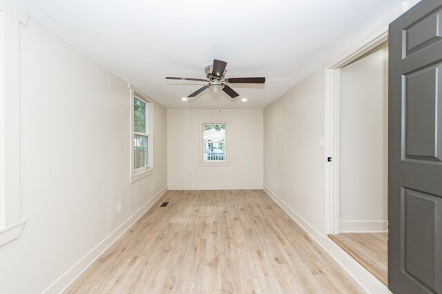 empty room with ceiling fan and light hardwood / wood-style flooring