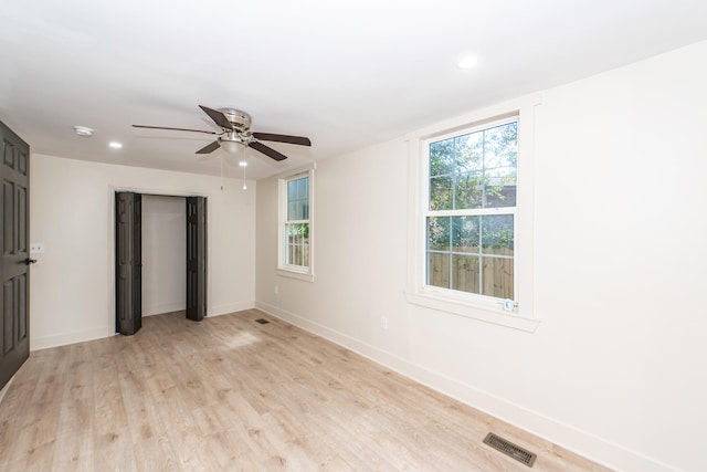 spare room with ceiling fan and light wood-type flooring