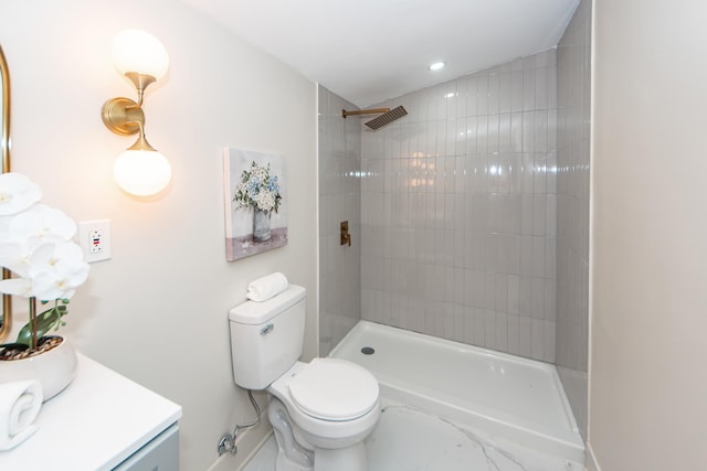 bathroom featuring vanity, toilet, and tiled shower