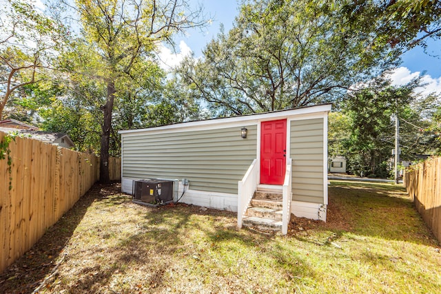 view of outbuilding featuring central AC and a yard