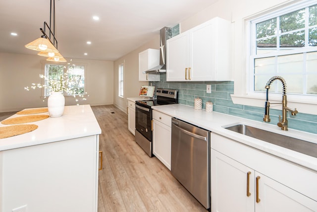 kitchen with stainless steel appliances, white cabinetry, light hardwood / wood-style floors, and decorative light fixtures