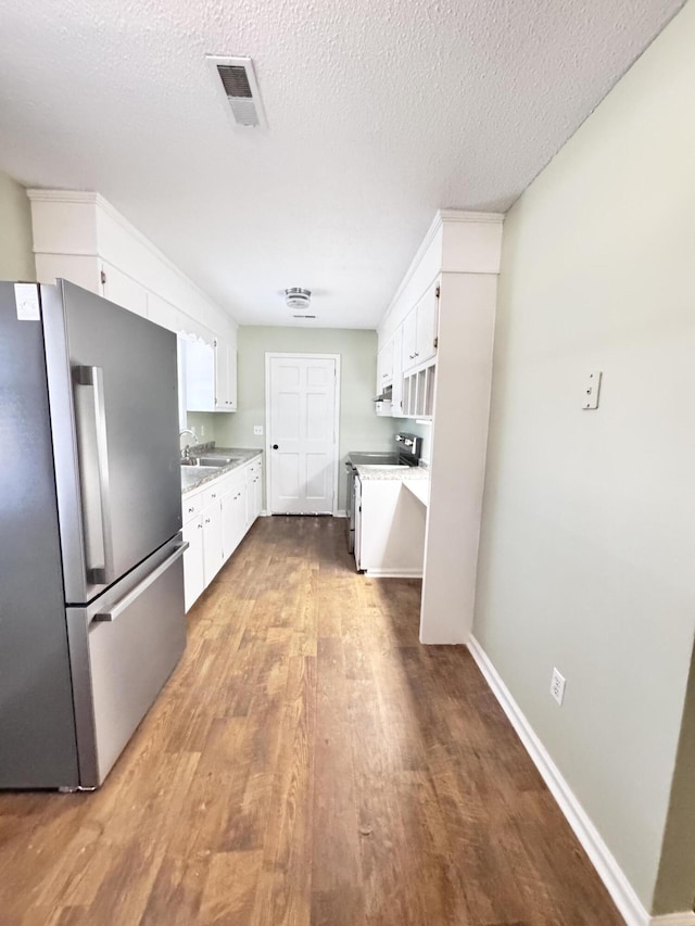 kitchen featuring a textured ceiling, sink, stainless steel appliances, and white cabinetry