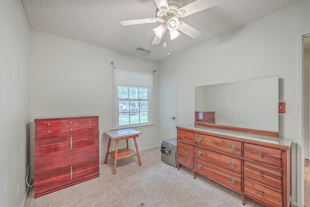 bedroom featuring light carpet, visible vents, ceiling fan, and a textured ceiling