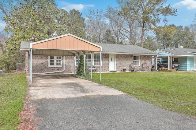 ranch-style home with a detached carport, aphalt driveway, roof with shingles, a front yard, and brick siding