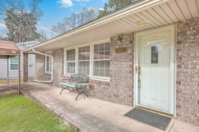 view of exterior entry featuring brick siding