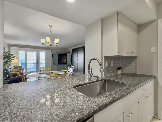 kitchen featuring decorative backsplash, dark stone counters, white cabinetry, light tile patterned flooring, and stainless steel appliances