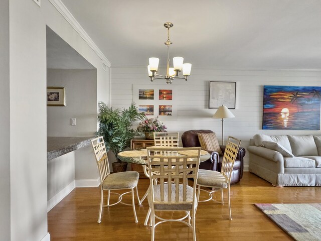 interior space with crown molding, wood-type flooring, and a notable chandelier