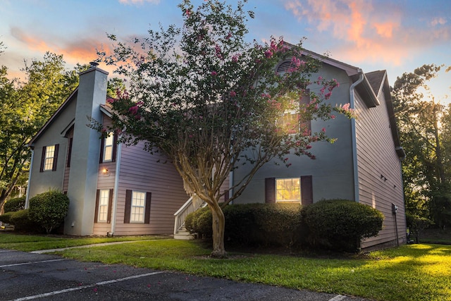 7950 Parklane Ct Unit C, North Charleston, SC 29418 - property exterior at dusk with a chimney, a yard, and uncovered parking