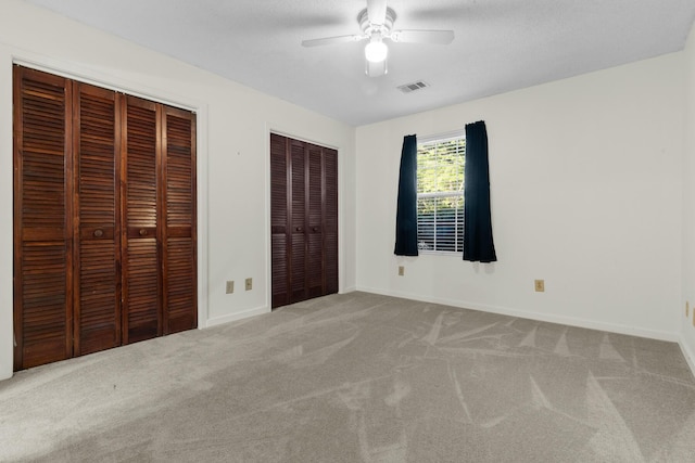 7950 Parklane Ct Unit C, North Charleston, SC 29418 - unfurnished bedroom featuring multiple closets, carpet, and a ceiling fan